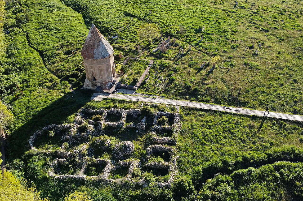 Gevaş'ta yeşil yamaçta duran Halime Hatun Kümbeti ve önündeki mezarlık alanı, havadan görünüm